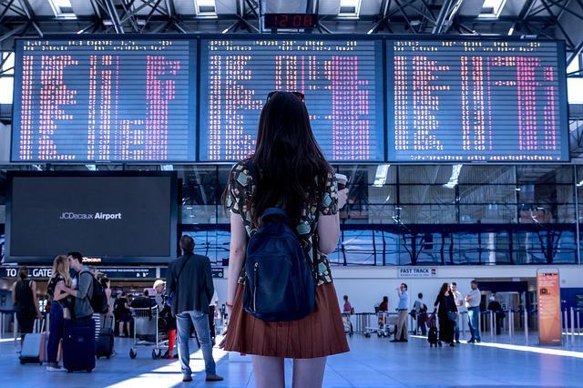 woman standing in the airport looking at her flight time